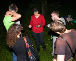 With participants of the seminar 'Bat research and conservation in Belarus' searching for bats in Roshta. We heard and saw Eptesicus nilssonii, but didn't catch anything. Except branches of pine tree and mosquitos. Lena Godlevska explains how to use a bat detector for participants of 'Bat research and conservation in Belarus' in Roshta Park, Minsk, Belarus (Photo: Dennis Wansink)